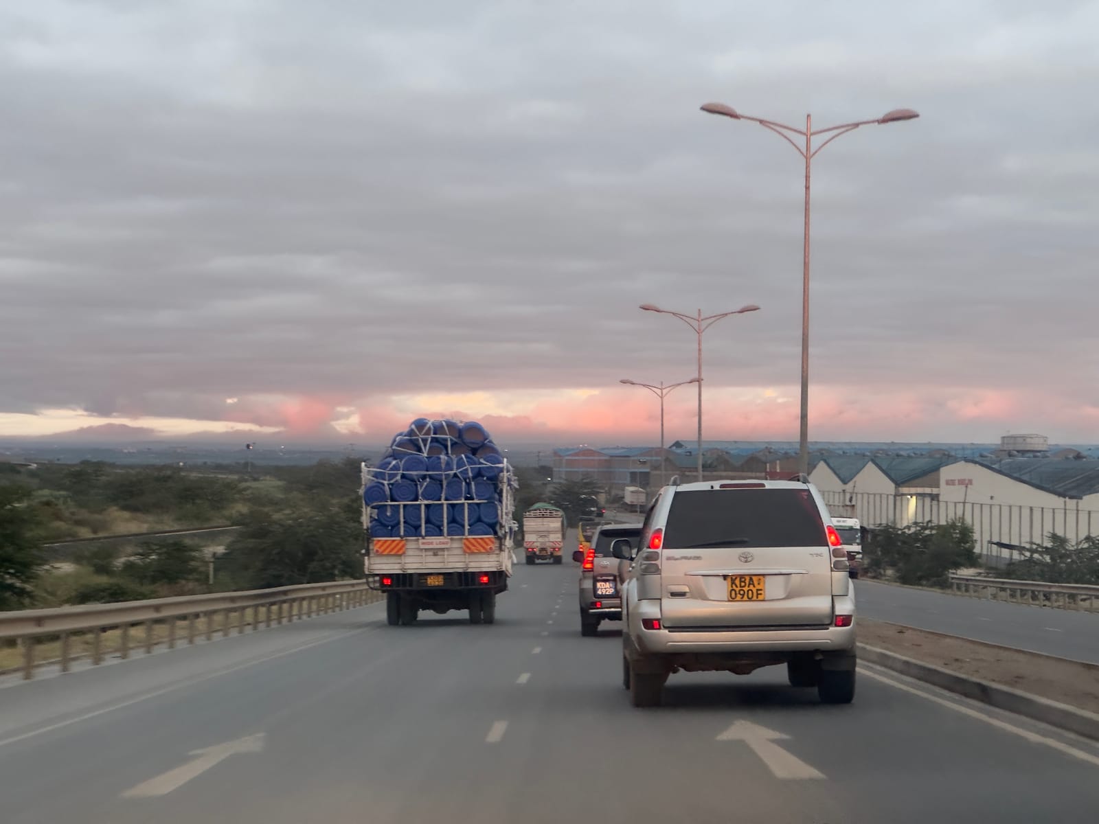 Cars and a heavily loaded lorry on a road in Embakasi South, Nairobi, at dusk (file photo, 2023; not the section to be upgraded).