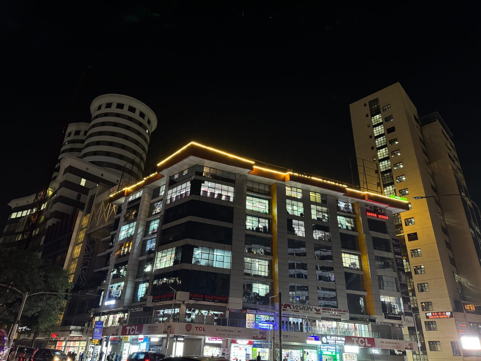Lit office and commercial buildings along Kimathi Street in Nairobi's CBD at night (file photo, 2025).