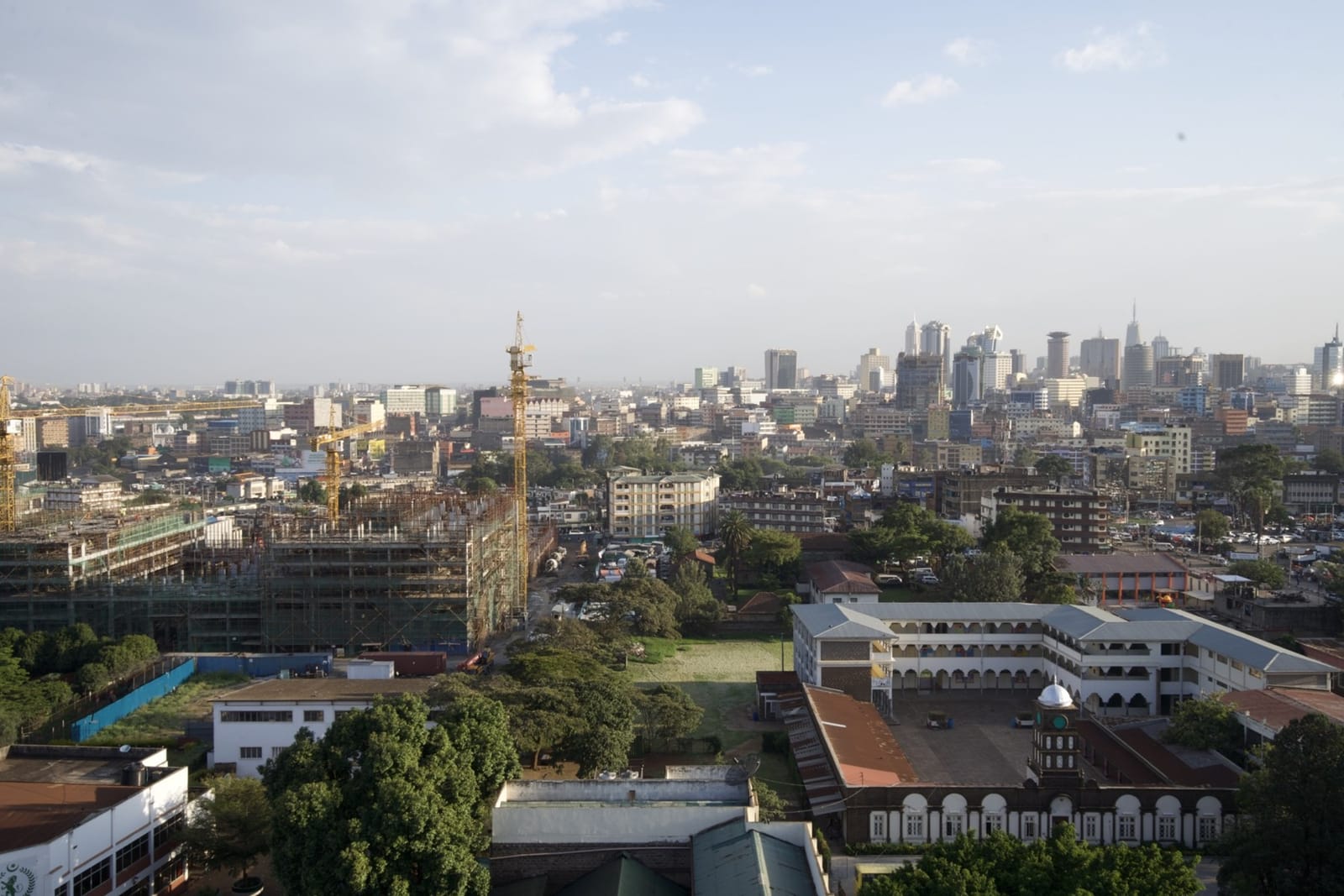 School buildings in the foreground, with a construction crane and the Nairobi skyline behind (file photo, 2022).